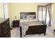 Bedroom features a dark wood bed frame with decorative pillows, curtains, and neutral colored walls at 5627 Isleworth Ct, Atlanta, GA 30349
