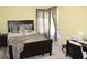 Bedroom features a dark wood bed frame with decorative pillows, curtains, and neutral colored walls at 5627 Isleworth Ct, Atlanta, GA 30349