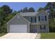 Charming two-story home with gray siding, dark shutters, attached two-car garage, and well-manicured landscaping at 5627 Isleworth Ct, Atlanta, GA 30349