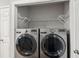 Laundry room with stainless steel washer and dryer next to a storage closet at 2542 Albion Farm Way, Duluth, GA 30097