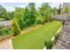 Elevated view of the backyard featuring pristine artificial turf, manicured landscaping, and a charming stone retaining wall at 3785 Allegretto Cir # 230, Atlanta, GA 30339