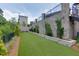 Inviting backyard showcases lush artificial turf, manicured greenery, and an elegant stone retaining wall at 3785 Allegretto Cir # 230, Atlanta, GA 30339