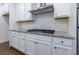 A modern kitchen features white cabinets, subway tile backsplash, and stainless steel vent hood at 3785 Allegretto Cir # 230, Atlanta, GA 30339