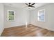 A bedroom with a ceiling fan, two windows, and modern vinyl plank flooring at 657 Woods Nw Dr, Atlanta, GA 30318