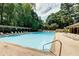 A large community pool surrounded by trees, lounge chairs and shaded seating areas at 3083 Colonial Way # N, Atlanta, GA 30341