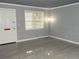 Bright living room with window, light gray walls, and wood-look tile floors at 3083 Colonial Way # N, Atlanta, GA 30341