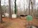 Spacious backyard with storage shed, wooden shelter, and a small greenhouse at 3738 Windy Hill Se Dr, Conyers, GA 30013