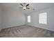 This spacious bedroom features a bright window, ceiling fan, neutral paint and soft carpet at 455 Charleston Pl, Villa Rica, GA 30180