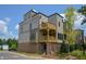 Stylish three-story condo featuring dual wooden balconies and neutral-toned siding with a partial brick facade at 1121 Rivard Nw Cir, Atlanta, GA 30318