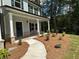 Inviting covered front porch with walkway and professionally landscaped yard at 66 Pine Creek Ct, Dallas, GA 30157