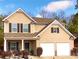 Two-story home with a two-car garage, covered porch, and manicured landscaping at 139 Concord Pl, Hiram, GA 30141