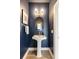 Elegant half bathroom featuring a pedestal sink, stylish lighting, navy blue paint, and modern fixtures at 22 Airline Ne St # 403, Atlanta, GA 30312