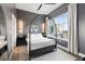 Modern bedroom with gray accent walls, a metal bed frame, and natural light from the large window at 22 Airline Ne St # 403, Atlanta, GA 30312