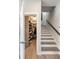 Hallway leading to staircase features an open closet with custom shelving for organized storage at 22 Airline Ne St # 403, Atlanta, GA 30312