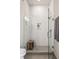 Modern shower with glass enclosure, white subway tile, a wooden bench, and gray tile flooring at 22 Airline Ne St # 403, Atlanta, GA 30312