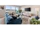 Bright living room featuring a plush blue sofa, stylish decor, and large windows offering city views at 22 Airline Ne St # 403, Atlanta, GA 30312