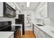 Modern kitchen with black appliances, white cabinets, subway tile backsplash and hardwood floors at 23310 Plantation Dr, Atlanta, GA 30324