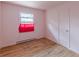 A simple bedroom with wood floor, window with a red curtain, and white door at 301 Lady Agatha Ct, Jonesboro, GA 30236