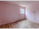 Bedroom with hardwood floors, window, pink walls, and baseboard radiator at 301 Lady Agatha Ct, Jonesboro, GA 30236