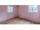 Bedroom featuring hardwood floors, pink walls, and windows bringing in lots of light at 301 Lady Agatha Ct, Jonesboro, GA 30236