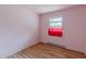 This bedroom includes wood-look floor, window with red curtain, and a radiator at 301 Lady Agatha Ct, Jonesboro, GA 30236