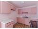 A view of a dated, but serviceable kitchen with pink cabinetry and a double basin sink at 301 Lady Agatha Ct, Jonesboro, GA 30236