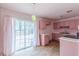 Cozy pink kitchen with natural light, classic cabinets and sliding glass doors to the backyard at 301 Lady Agatha Ct, Jonesboro, GA 30236