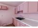 A view of a pink kitchen features a double basin sink and pink upper and lower cabinets at 301 Lady Agatha Ct, Jonesboro, GA 30236