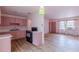 Kitchen opens into the living room with matching wood flooring, natural light, and pink walls at 301 Lady Agatha Ct, Jonesboro, GA 30236