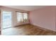 Open living room with hardwood floors, radiator and natural light provided by large windows and glass door at 301 Lady Agatha Ct, Jonesboro, GA 30236