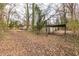 Leafy backyard offering a glimpse of the house and a covered carport at 3483 Napoleon St, Atlanta, GA 30337