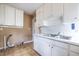 Basic kitchen with white cabinets, a double sink, and visible plumbing at 3483 Napoleon St, Atlanta, GA 30337