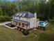 Breathtaking aerial view of the home featuring a pool, sprawling lawn, and extensive landscaping at 650 Jones Rd, Roswell, GA 30075