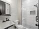 Modern bathroom featuring a walk-in shower with glass door, white brick accent wall, and black fixtures at 650 Jones Rd, Roswell, GA 30075