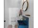 Modern bathroom with a blue concrete sink, gold fixtures and a round mirror at 650 Jones Rd, Roswell, GA 30075