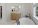 Modern bathroom with a freestanding tub, a wooden vanity and wainscotting walls at 650 Jones Rd, Roswell, GA 30075