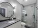 Sleek bathroom with a stand up glass shower and a modern vanity with a round mirror at 650 Jones Rd, Roswell, GA 30075