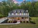 Stunning two-story white farmhouse with a covered front porch and professional landscaping at 650 Jones Rd, Roswell, GA 30075