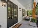 Inviting front porch featuring a porch swing, black framed double-door entry, and warm lighting at 650 Jones Rd, Roswell, GA 30075