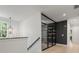 Hallway with modern design elements, hardwood floors, a built-in storage cabinet, and staircase at 650 Jones Rd, Roswell, GA 30075