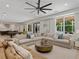 Large living room featuring a sectional sofa, a ceiling fan, and oversized windows at 650 Jones Rd, Roswell, GA 30075