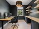 Sleek home office with dark walls, built-in shelves, wood floors, and modern furnishings at 650 Jones Rd, Roswell, GA 30075