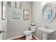 Stylish powder room with pedestal sink and decorative mirror at 154 Calla Dr, Douglasville, GA 30134