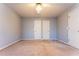 A gray bedroom with standard closet doors and beige carpeting at 2430 Bretdale Rd, Duluth, GA 30096