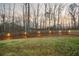 Large backyard with green grass and illuminated wooden fence for privacy at 260 Harmony Woods Dr, Dallas, GA 30157