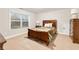 Well-lit bedroom featuring a wooden bed frame, dresser, and side table at 260 Harmony Woods Dr, Dallas, GA 30157