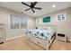 Bright bedroom featuring a ceiling fan, large window, and a bed with starfish patterned bedding at 260 Harmony Woods Dr, Dallas, GA 30157