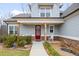 A welcoming porch with a red door, rocking chair, and charming landscaping creates a warm entry at 260 Harmony Woods Dr, Dallas, GA 30157