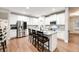 Bright kitchen boasts white cabinetry, stainless steel appliances, granite counters, and a large center island at 260 Harmony Woods Dr, Dallas, GA 30157