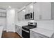 Modern kitchen features sleek gray cabinets, stainless steel appliances, white subway tile backsplash and granite countertops at 404 Village Ln, Fairburn, GA 30213